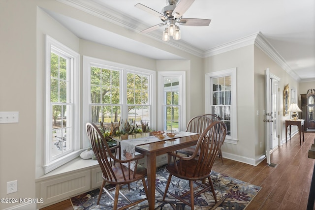 dining space featuring dark wood-style flooring, baseboards, crown molding, and ceiling fan