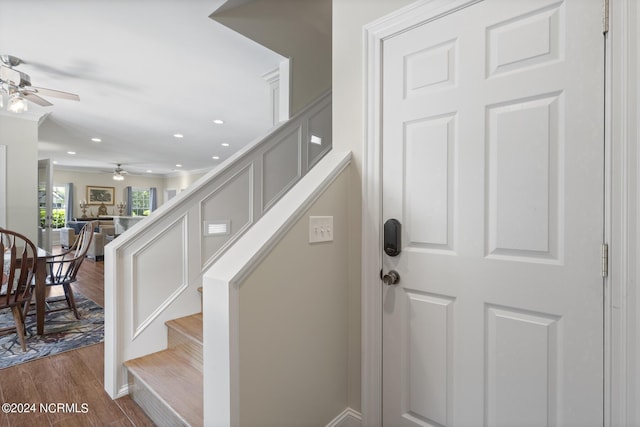 stairway with ceiling fan, recessed lighting, and wood finished floors