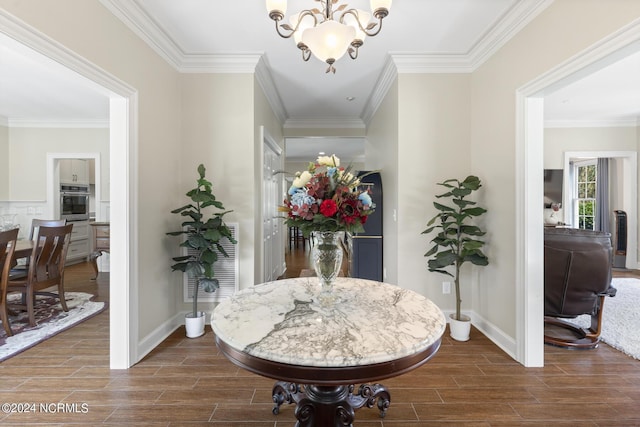 hall featuring a chandelier, crown molding, and wood tiled floor