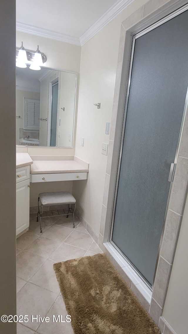 bathroom featuring baseboards, ornamental molding, a shower stall, vanity, and tile patterned floors
