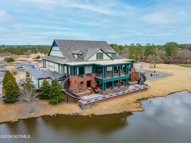 rear view of property featuring a water view and a balcony