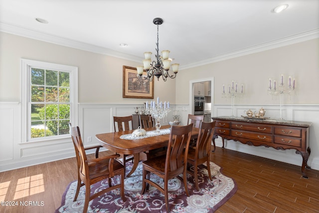 dining room featuring ornamental molding, dark wood-type flooring, and a notable chandelier