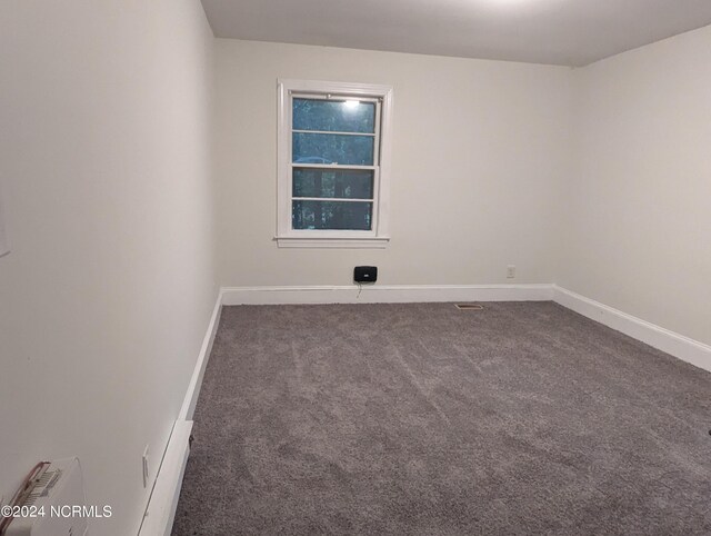 hallway with dark colored carpet