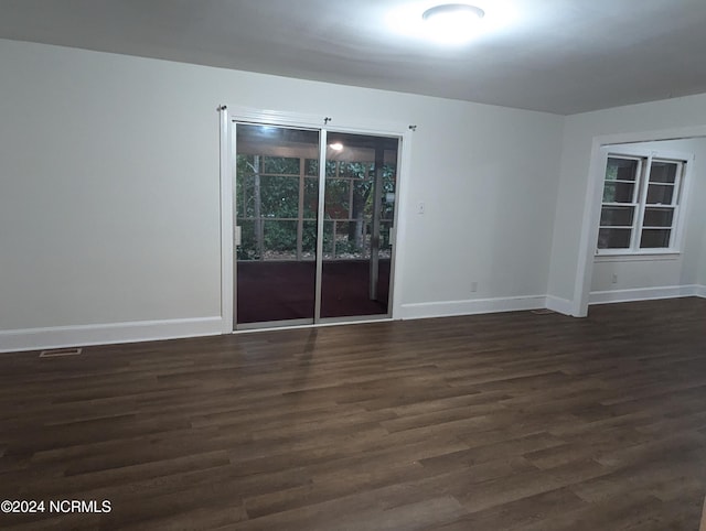 empty room with dark hardwood / wood-style flooring