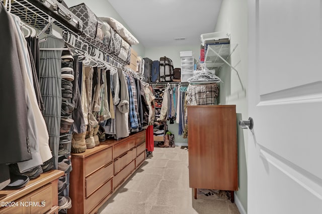 spacious closet featuring light colored carpet