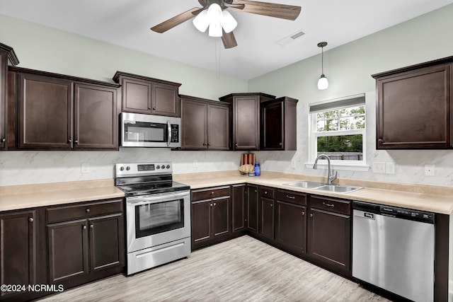 kitchen with ceiling fan, pendant lighting, sink, appliances with stainless steel finishes, and light wood-type flooring