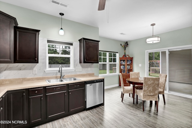 kitchen featuring light wood-type flooring, dishwasher, hanging light fixtures, and sink