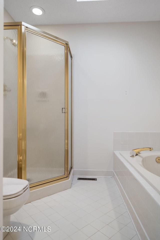 bathroom featuring toilet, tile patterned floors, and separate shower and tub