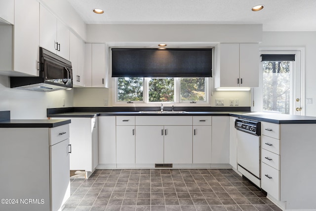 kitchen with white dishwasher, sink, a textured ceiling, and white cabinetry