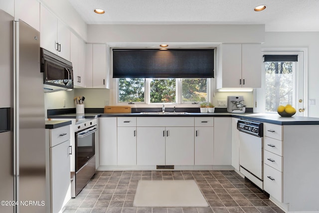 kitchen with a textured ceiling, white cabinetry, sink, and stainless steel appliances