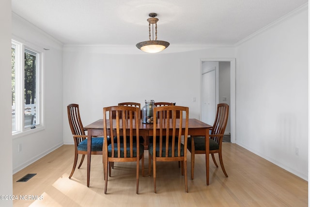 dining area featuring ornamental molding and light wood-type flooring