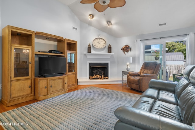 living room with ceiling fan, light wood-type flooring, and lofted ceiling