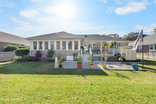 rear view of house featuring a shed, a patio, and a yard