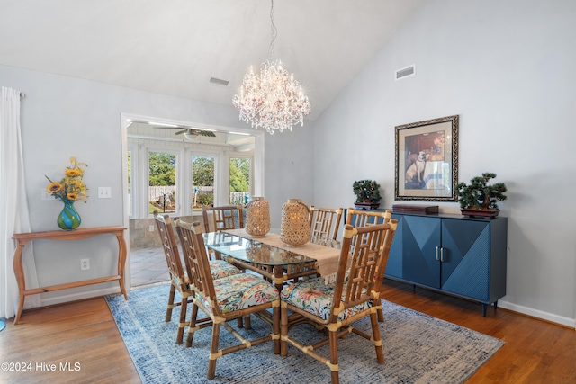 dining room featuring high vaulted ceiling, hardwood / wood-style flooring, and ceiling fan with notable chandelier