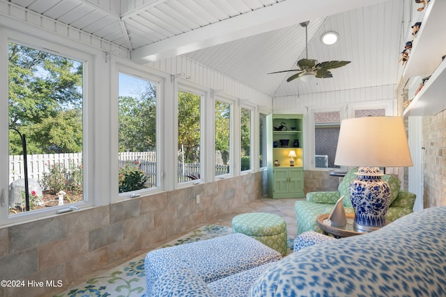 sunroom with lofted ceiling with beams, wood ceiling, ceiling fan, and plenty of natural light