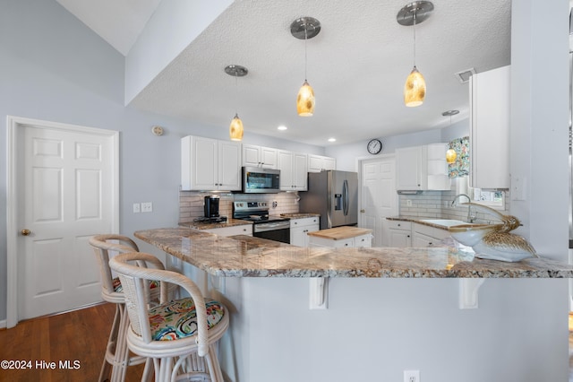 kitchen with kitchen peninsula, appliances with stainless steel finishes, light stone counters, and backsplash