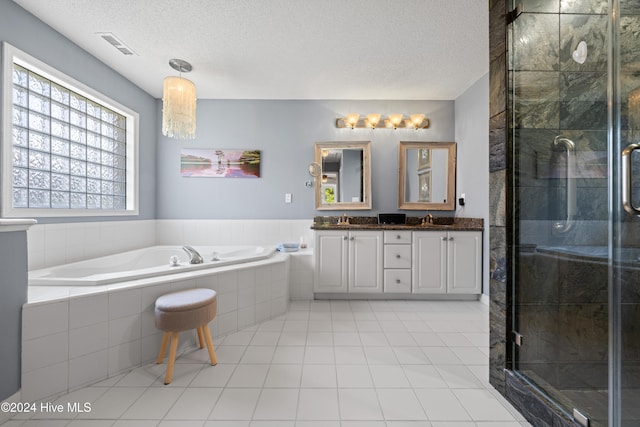 bathroom featuring vanity, tile patterned flooring, a textured ceiling, and plus walk in shower