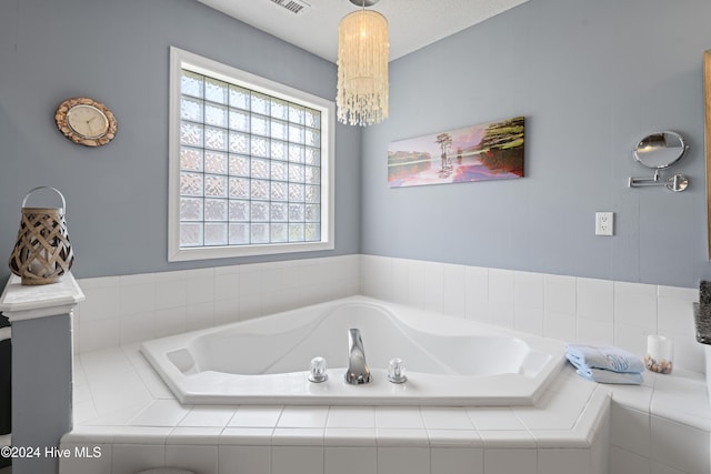 bathroom featuring tiled bath and a textured ceiling