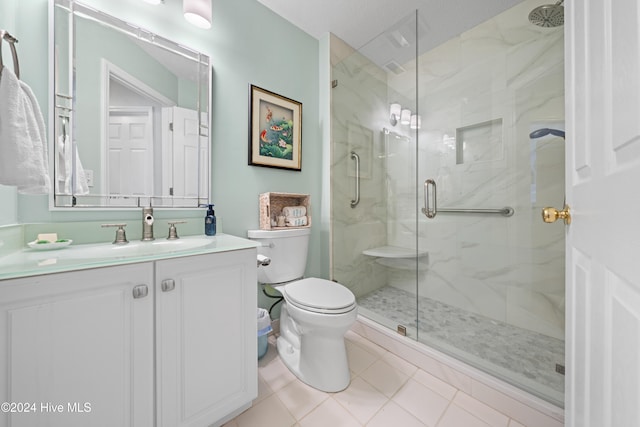 bathroom with tile patterned flooring, an enclosed shower, vanity, and toilet