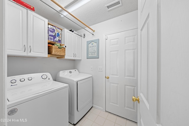 laundry room featuring cabinets, a textured ceiling, and independent washer and dryer