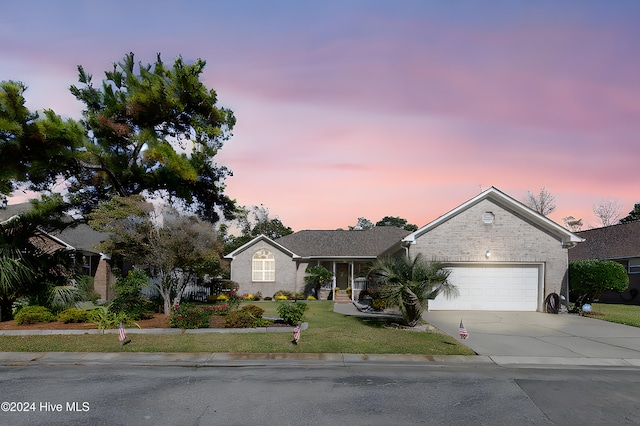 view of front of house with a garage and a yard