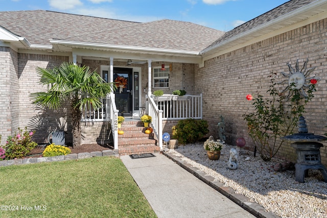 entrance to property featuring a yard and a porch