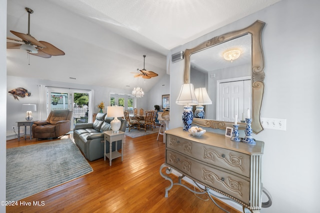 living room with hardwood / wood-style floors, ceiling fan, and vaulted ceiling