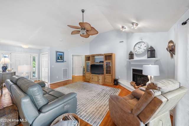 living room with light wood-type flooring, vaulted ceiling, and ceiling fan