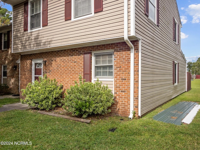 view of side of home with a yard