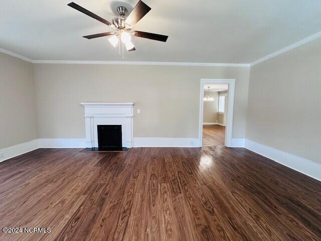 unfurnished living room with ornamental molding, ceiling fan, and dark hardwood / wood-style floors