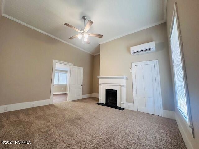 unfurnished living room featuring ceiling fan, carpet floors, plenty of natural light, and an AC wall unit