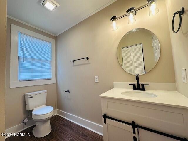 bathroom with crown molding, vanity, toilet, and hardwood / wood-style flooring