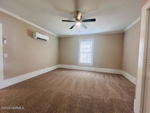 empty room with ornamental molding, ceiling fan, carpet floors, and a wall mounted air conditioner