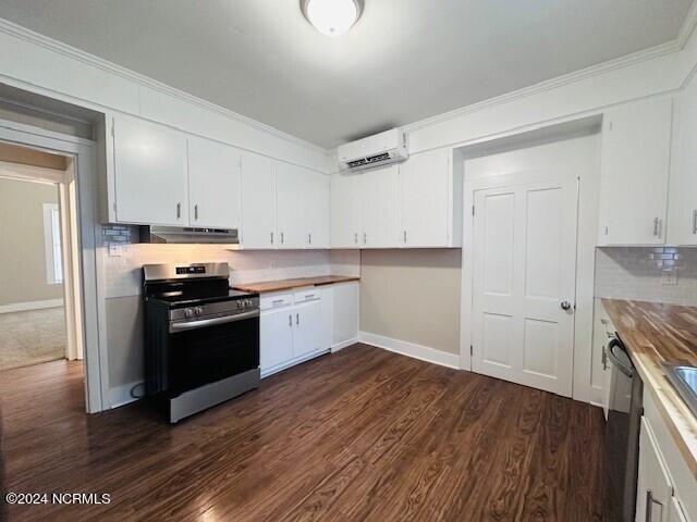 kitchen featuring appliances with stainless steel finishes, white cabinets, an AC wall unit, dark hardwood / wood-style flooring, and wooden counters