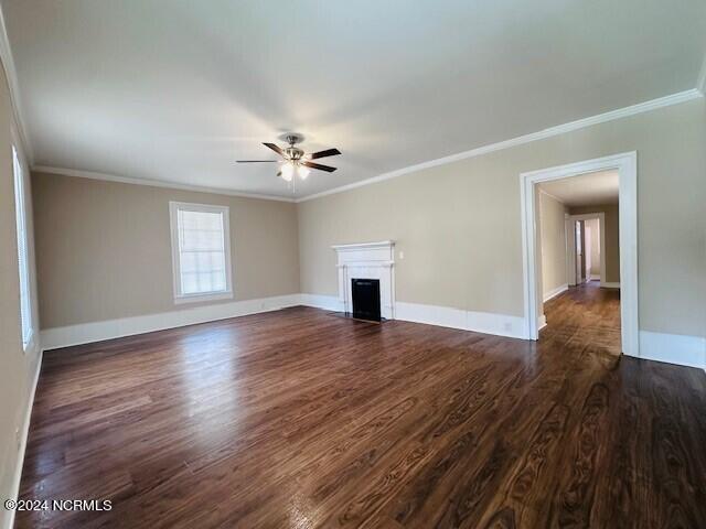 unfurnished living room featuring ceiling fan, ornamental molding, and dark hardwood / wood-style flooring