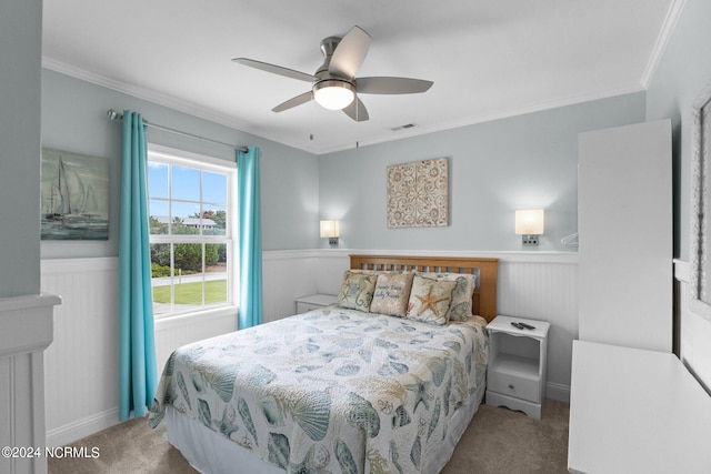 carpeted bedroom with ornamental molding and ceiling fan