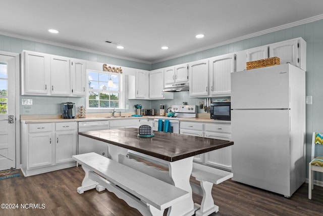 kitchen featuring dark hardwood / wood-style floors, ornamental molding, white appliances, and white cabinetry