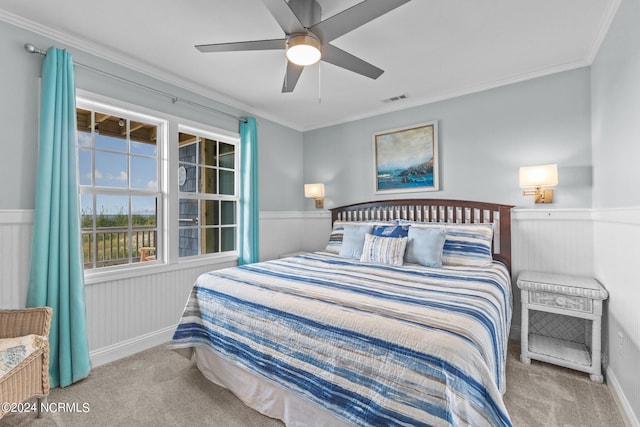 carpeted bedroom featuring crown molding and ceiling fan