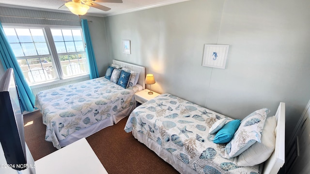 carpeted bedroom featuring ceiling fan and crown molding