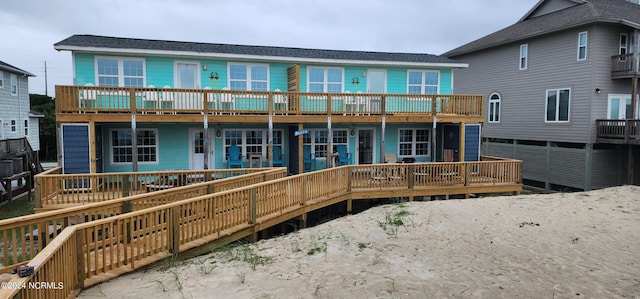 rear view of property featuring a balcony and a deck