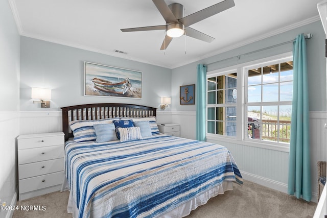 carpeted bedroom featuring ceiling fan and crown molding