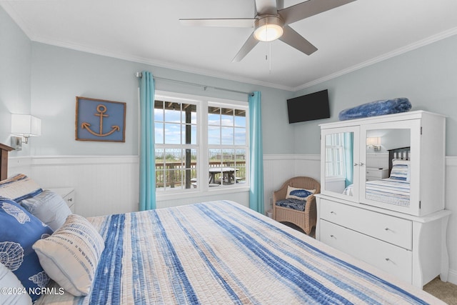 carpeted bedroom featuring crown molding and ceiling fan