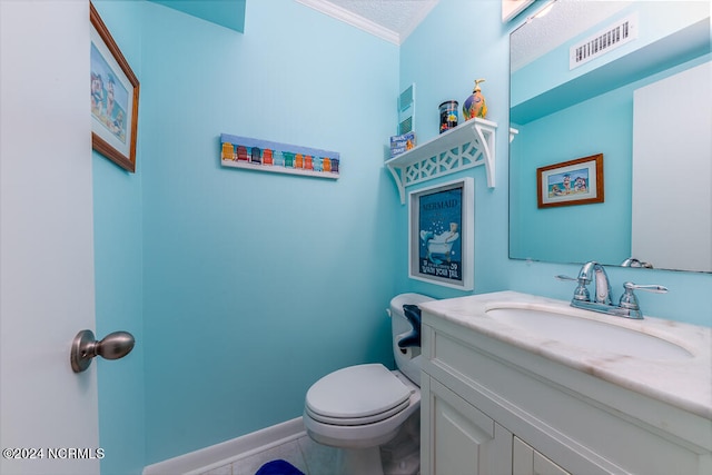 bathroom featuring vanity, a textured ceiling, ornamental molding, toilet, and tile patterned floors