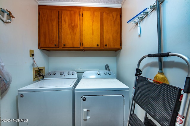 clothes washing area with separate washer and dryer, ornamental molding, and cabinets