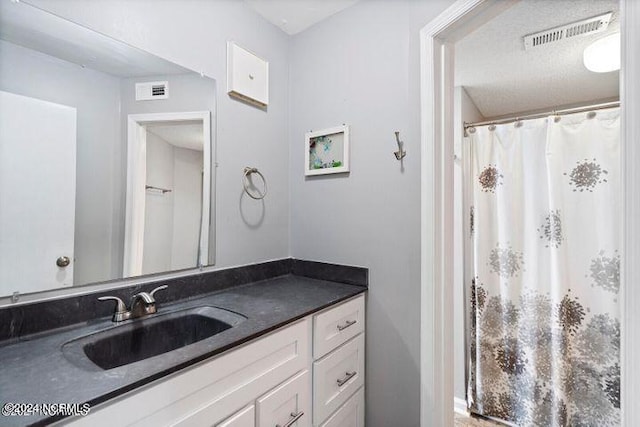 bathroom with walk in shower and vanity