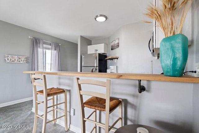 kitchen with stainless steel refrigerator and a breakfast bar