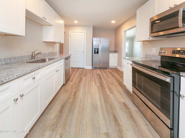 kitchen featuring white cabinets, appliances with stainless steel finishes, sink, and light hardwood / wood-style flooring