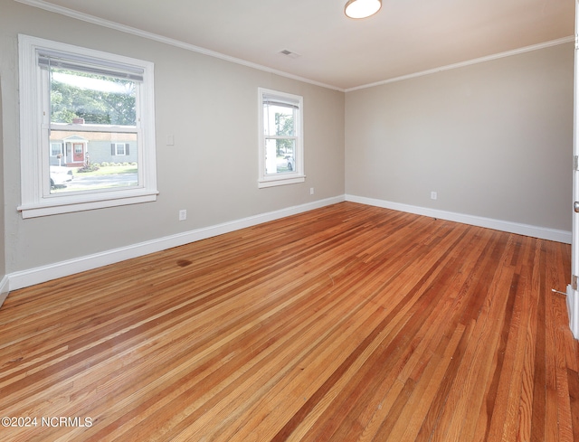 unfurnished room with light hardwood / wood-style flooring, a wealth of natural light, and crown molding