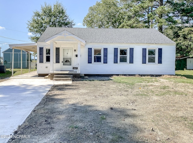 view of front facade with cooling unit and a carport