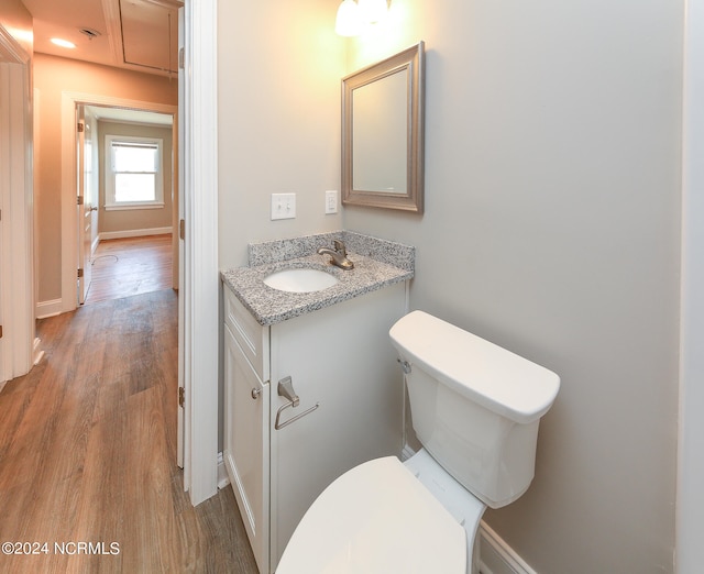 bathroom featuring wood-type flooring, vanity, and toilet